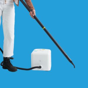 south Asian female holding a steam cleaner on a blue background